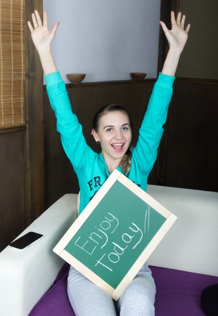 beautiful slim woman in a tracksuit with chalkboard, Enjoy todayの写真素材