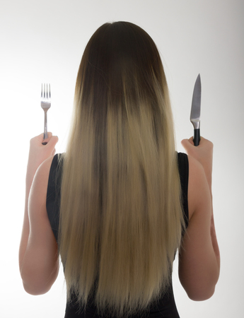 close-up slim girl in a bathing suit, a girl holding a knife and fork, concept hungry girlの写真素材