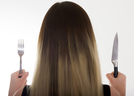 close-up slim girl in a bathing suit, a girl holding a knife and fork, concept hungry girlの写真素材