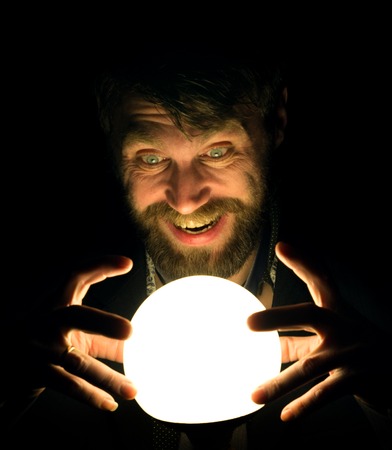 bearded man in the dark, holding in front of a lamp, expresses different emotions.の写真素材