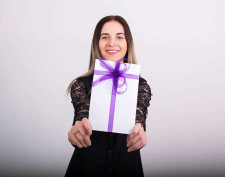 holiday woman happy smile hold gift card present, excited woman wear dress.の写真素材