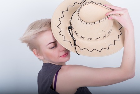 Closeup portrait of sexy whiteheaded  young woman with red lips, holding a cowboy hat.の写真素材