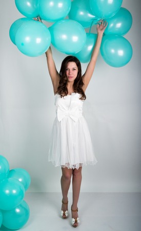 beautiful curly girl in a white dress and sunglasses in the style of disco playing with balloons.の写真素材