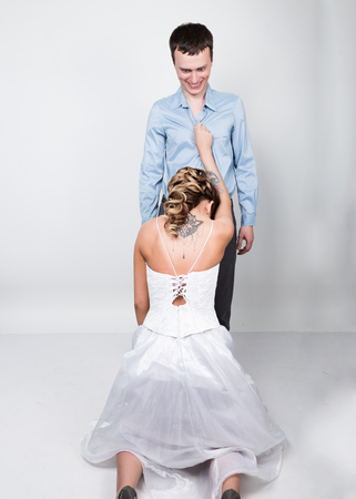 beautiful young couple in love, bride knelt before the groom. provocation playful couple.の写真素材