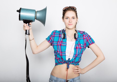 teenager girl in denim shorts and a plaid shirt express different emotions. counselor at a summer camp yelling through bullhorn.の写真素材