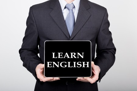 technology, internet and networking in business concept - businessman holding a tablet pc with learn english sign. Internet technologies in business. technology, internet and networking in business concept - businessman holding a tablet pc with learn english sign. Internet technologies in business.