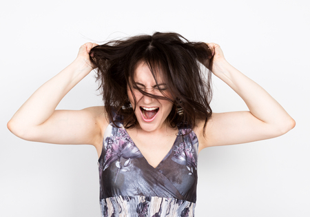 beautiful young brunette woman in a colorful dress posing and expresses different emotions. woman's...