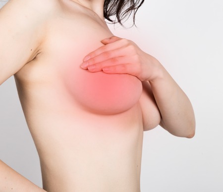 Breast cancer self check. Young woman examining her breast for lumps or signs of breast cancer. healthy lifestyle concept.の写真素材