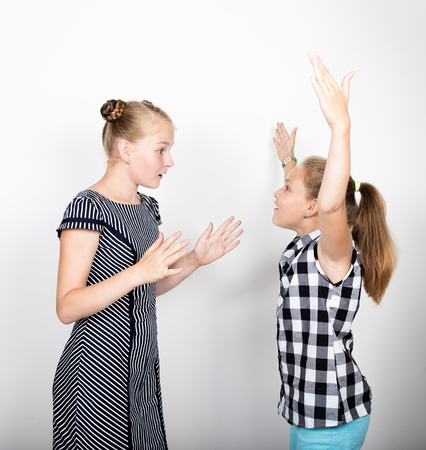 Two cute little girlfriend expressing different emotions. Funny kids. Best friends pamper and posing.の写真素材