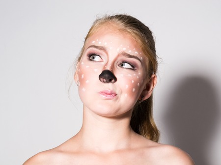 Beautiful girl with funny make-up, expresses different emotions. Funny image of beautiful pretty girl.の写真素材