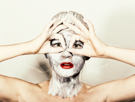 abstract art makeup. Face and neck girls smeared with gray colors and bright red lips. Holi Festival.の写真素材