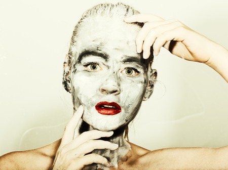 abstract art makeup. Face and neck girls smeared with gray colors and bright red lips. Holi Festival.の写真素材