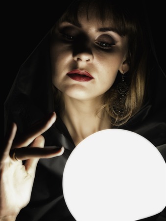 mysterious young woman wonders on a large luminous ball. on a dark background.