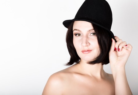 Closeup portrait of beautiful sexy young woman in black hat, posing.