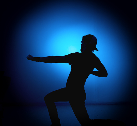 silhouette Rocker man posing on blue background.