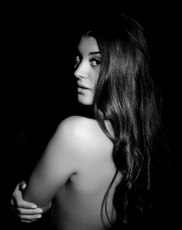 silhouette of nude young beautiful woman on black background, black and whiteの写真素材