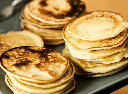 Homemade sweet pancakes with fruit jam on a white plate. Breakfast with stack topped blueberry jam and walnuts.の写真素材