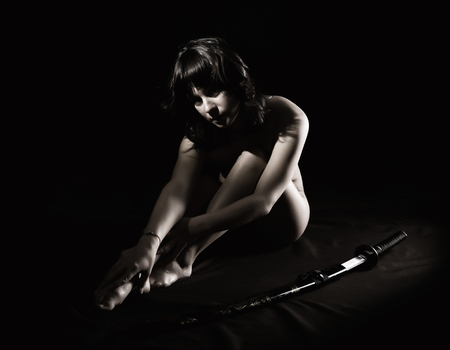 sexy nude woman with sword on dark backgroundの写真素材