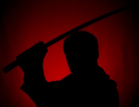 Silhouette of man with sword on red backgroundの写真素材