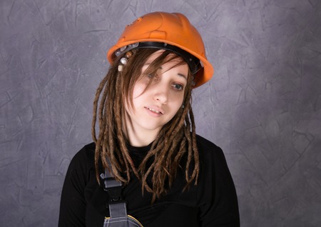 girl in safety helmet orange vest holding hammer toolの写真素材