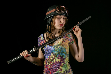 Female gothic warrior in pilot old glasses posing with katana swordの写真素材