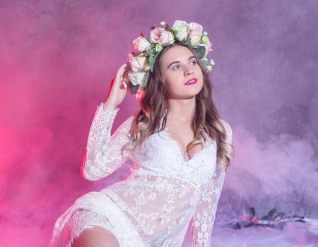Beautiful woman in lace underwear with flower wreath on her head in the smoke. Beauty fashion and spring womanの写真素材