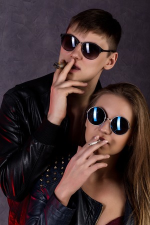 Expressive beautiful girl and handsome guy smoking cigarette before passionate night.の写真素材