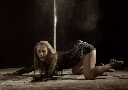 Beautiful expressive dencer dancing at studio with flour