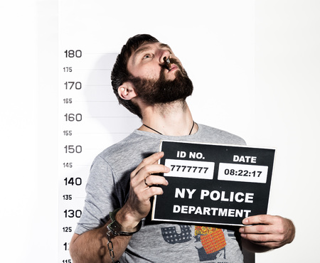 bearded man in handcuffs with sigarette, Criminal Mug Shotsの写真素材
