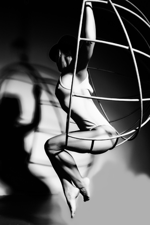 Silhouette of a sexy woman on a metal cage, black and whiteの写真素材