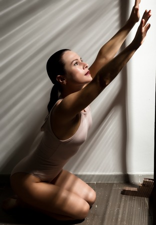 sexy woman in a beige swimsuit in a shadow stripeの写真素材
