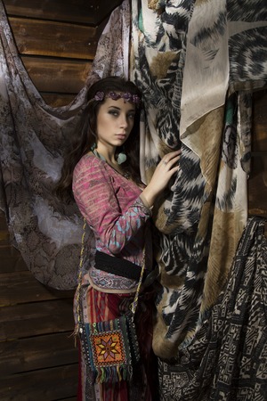 Young hippie boho woman poses with wildflowers on a wooden background.の写真素材