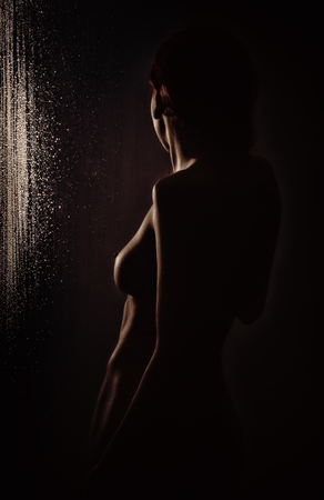 graceful naked young woman with big boobs and water droplets on a body.の写真素材