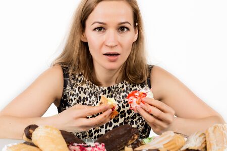 Young woman eating cupcakes with pleasure after a diet.