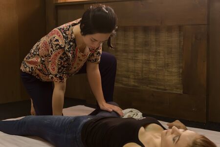 Foot massage in thai studio. Professional therapist giving traditional Thai massageの写真素材