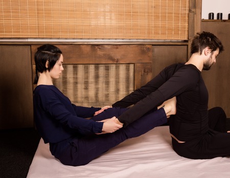 beautiful girl doing thai back massage in spa saloonの写真素材
