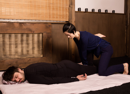 Foot massage in thai studio. Professional therapist giving traditional Thai massageの写真素材