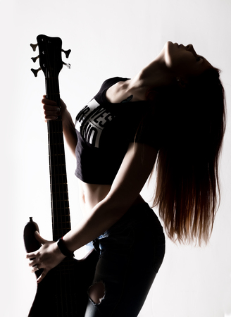 silhouette of rock woman playing on electric guitar on a white background.の写真素材