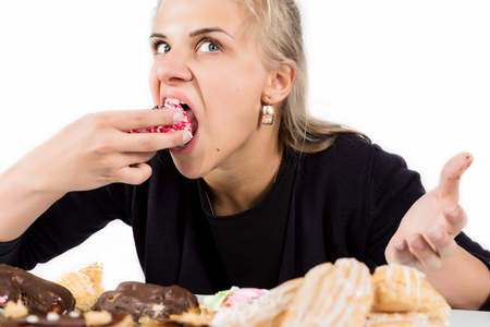 glutton woman eating cupcakes with frenzy after long dietの写真素材
