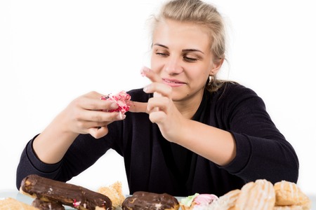 Young woman eating cupcakes with pleasure after a dietの写真素材