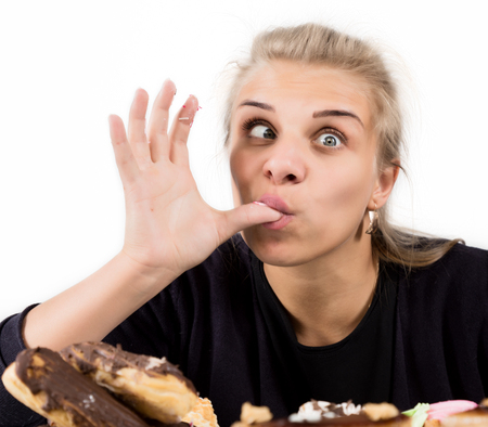 Young woman eating cupcakes with pleasure after a dietの写真素材