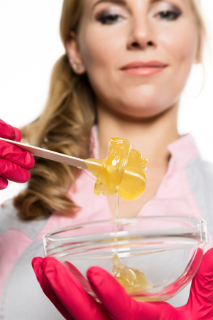 shugaring master in red gloves holds Wand with shugaring wax. depilation and beauty conceptの写真素材