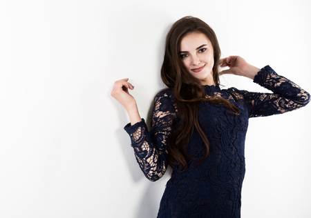 attractive young woman standing near white wall. free space for textの写真素材