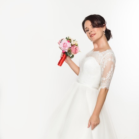 elegant bride on a light background. Beautiful wedding bouquet in a bride hands. free space for your textの写真素材