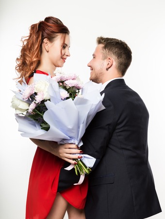 Guy gave a bouquet to a girlfriend on a date. Couple meeting for date on a light backgroundの写真素材