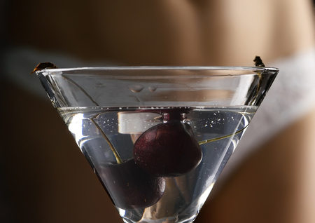 sexy young woman in a white panties prepares a cocktail in a dark. close-up buttocks and hipの写真素材