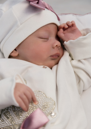 sleeping newborn baby in a wrap lying on a warm blanketの写真素材