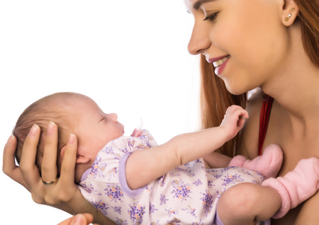 Pretty woman holding a newborn baby in her arms on a white backgroundの写真素材