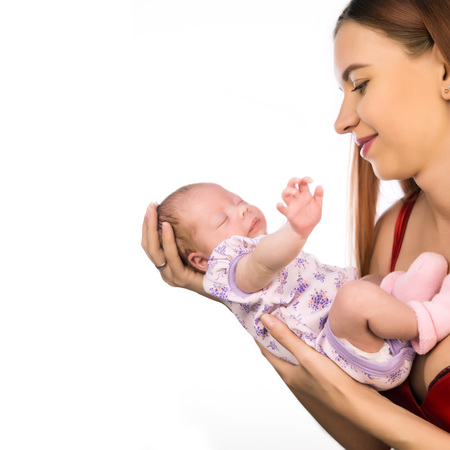 Pretty woman holding a newborn baby in her arms. Copy space, free space for your textの写真素材