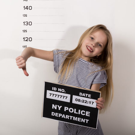 Young beautiful blonde child with a sign, Criminal Mug Shots. difficult children, social tensionの写真素材